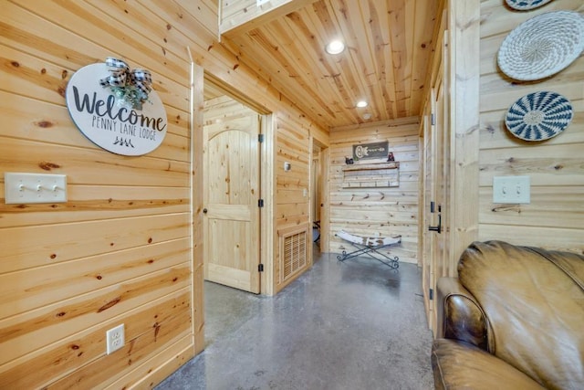 corridor featuring wooden ceiling and wooden walls