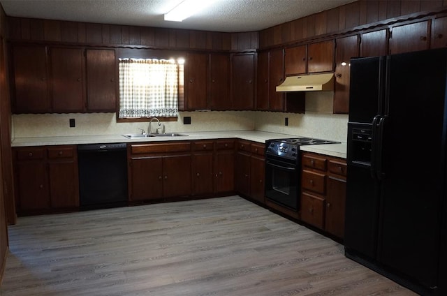 kitchen with black appliances, dark brown cabinets, light wood-type flooring, and sink