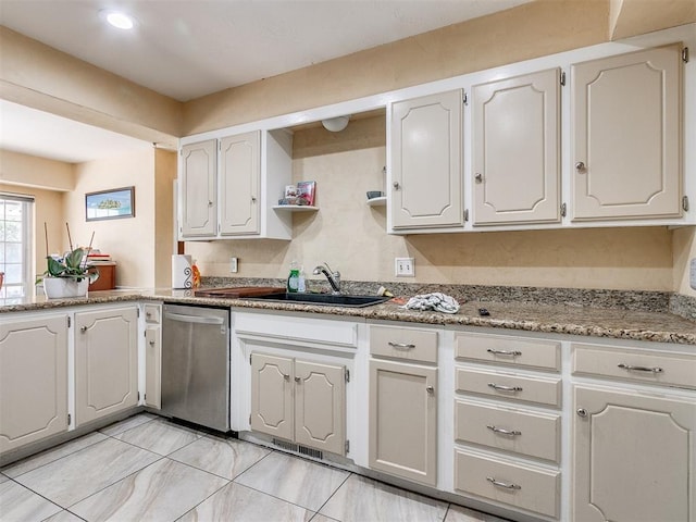 kitchen with white cabinetry, dishwasher, light stone countertops, and sink