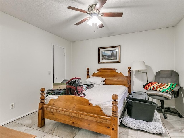 tiled bedroom with ceiling fan and a textured ceiling