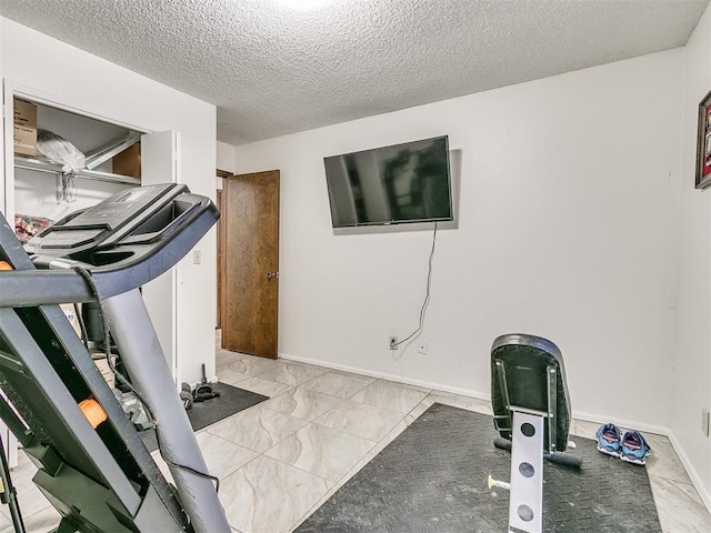 exercise room featuring a textured ceiling