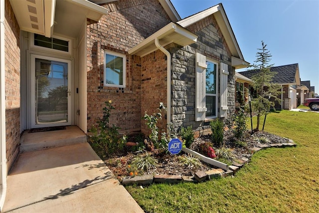 view of exterior entry featuring a yard