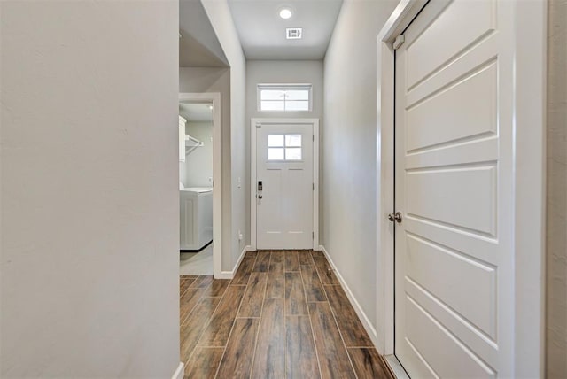 doorway to outside with washer / dryer and dark wood-type flooring