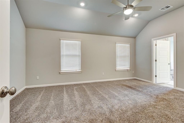 spare room featuring carpet floors, plenty of natural light, and lofted ceiling