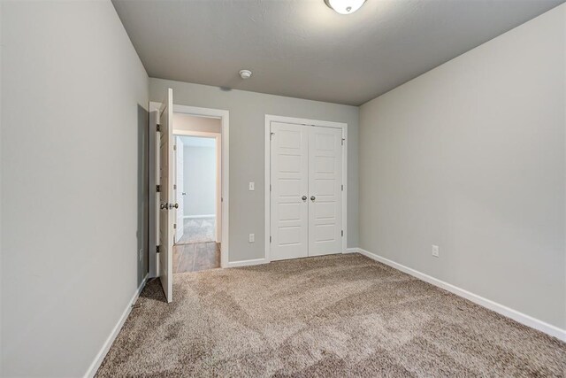 unfurnished bedroom with carpet flooring and a closet