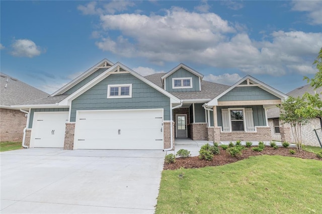 9216 NW 117th St, Yukon, OK 73099 - craftsman-style home with an attached garage, a front lawn, driveway, brick siding, and covered porch