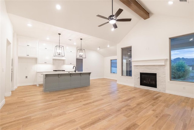 9216 NW 117th St, Yukon, OK 73099 - unfurnished living room with beam ceiling, recessed lighting, a sink, a ceiling fan, and light wood-style floors