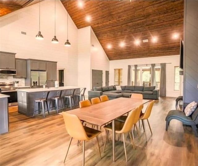 dining area featuring light hardwood / wood-style flooring, high vaulted ceiling, and wood ceiling