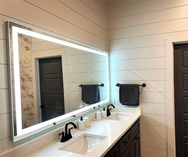 bathroom with vanity and wood walls