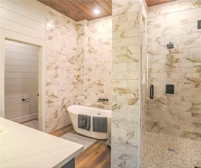 bathroom featuring hardwood / wood-style floors, vanity, and shower with separate bathtub