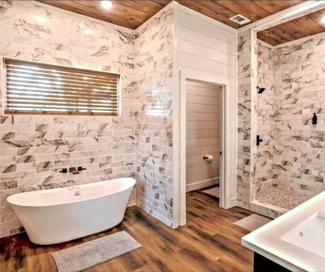 bathroom featuring vanity, hardwood / wood-style floors, a bathtub, and wooden ceiling