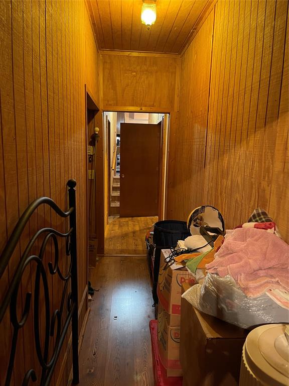 bedroom featuring wood ceiling, dark wood-type flooring, and wood walls