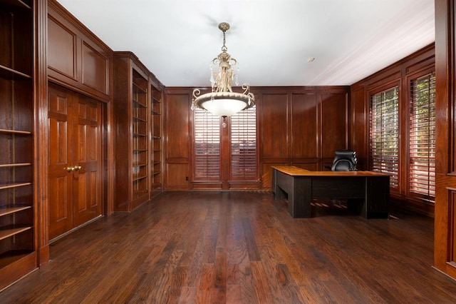 unfurnished office featuring dark hardwood / wood-style floors, wood walls, and built in features