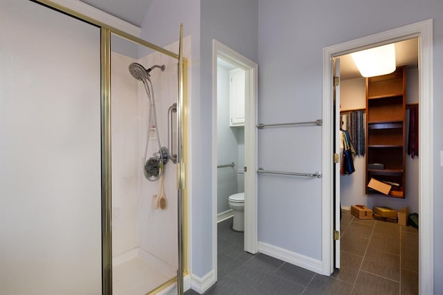 bathroom with tile patterned flooring, toilet, and a shower with shower door