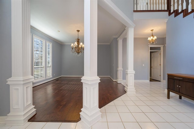 living room with a notable chandelier, light wood-type flooring, ornamental molding, and ornate columns