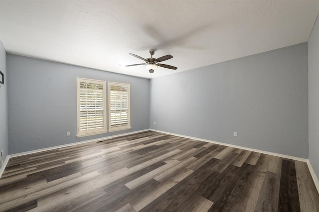 spare room with ceiling fan and dark wood-type flooring