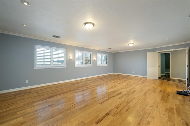 spare room with light wood-type flooring and crown molding