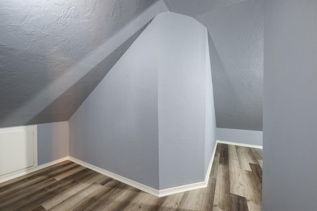 bonus room with lofted ceiling and hardwood / wood-style flooring