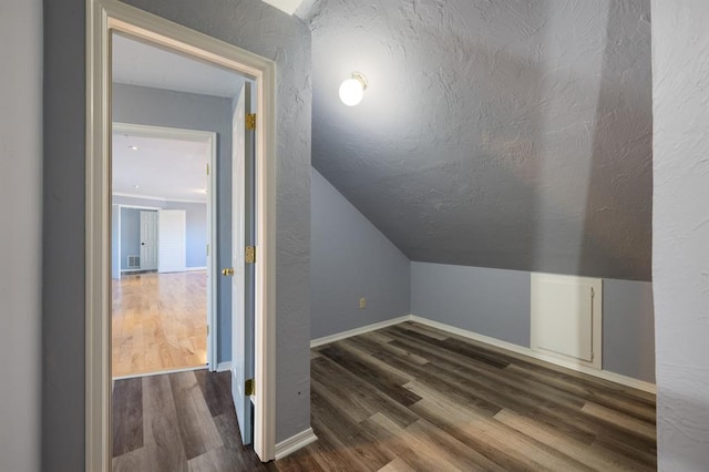 bonus room featuring lofted ceiling and dark wood-type flooring