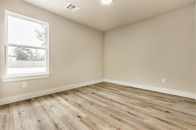 empty room featuring plenty of natural light and light hardwood / wood-style floors