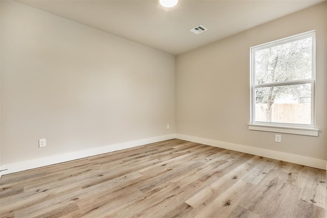 spare room featuring light hardwood / wood-style flooring and a wealth of natural light