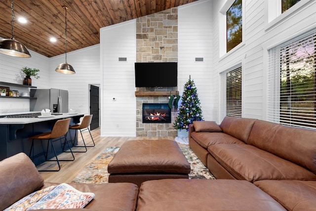 living room featuring light wood-type flooring, high vaulted ceiling, and plenty of natural light