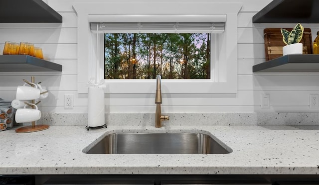 interior details featuring light stone counters and sink