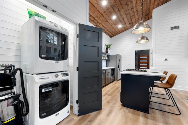 washroom with wooden walls, light hardwood / wood-style floors, stacked washing maching and dryer, and wood ceiling