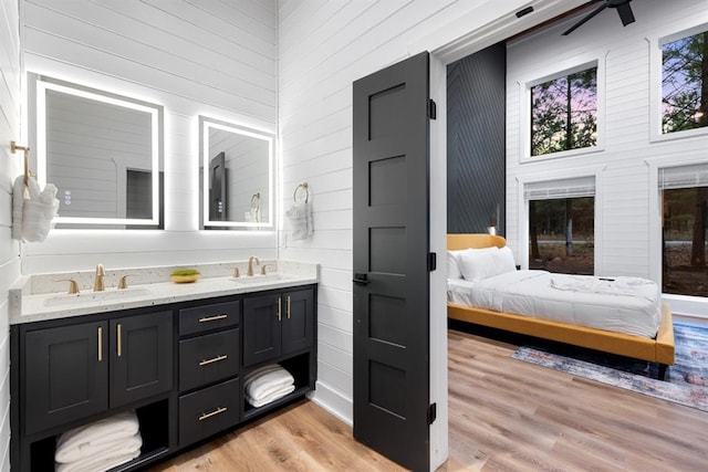 bathroom featuring vanity, ceiling fan, a towering ceiling, and wood-type flooring