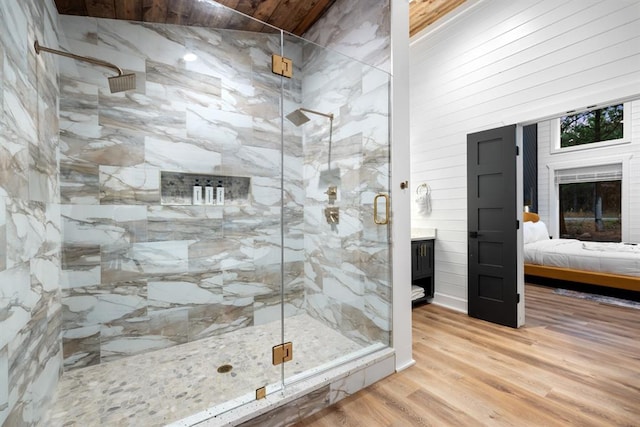 bathroom featuring a fireplace, hardwood / wood-style flooring, walk in shower, and wood walls