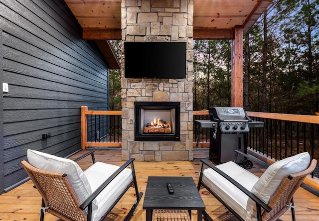 deck featuring an outdoor stone fireplace and grilling area