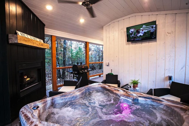 bedroom featuring lofted ceiling, wooden ceiling, a fireplace, and wood walls