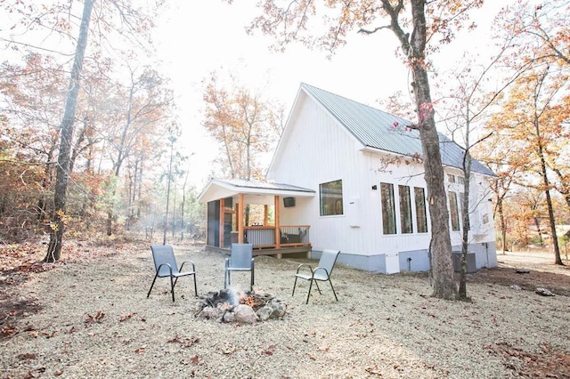 rear view of property featuring a fire pit