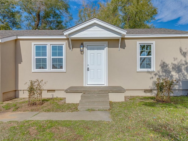 property entrance featuring a lawn