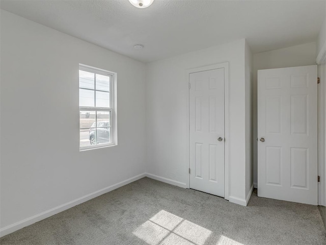 unfurnished bedroom featuring light colored carpet and a closet