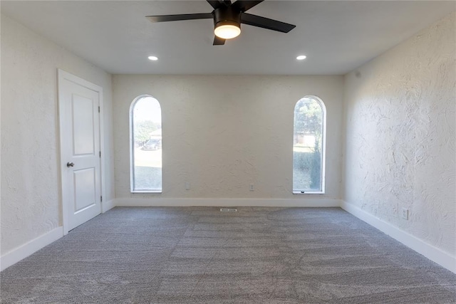 carpeted spare room featuring ceiling fan