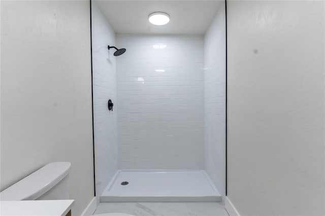 bathroom featuring tiled shower, vanity, and toilet