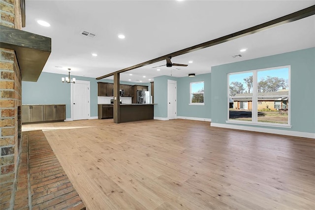 unfurnished living room with beam ceiling, light hardwood / wood-style flooring, and ceiling fan with notable chandelier