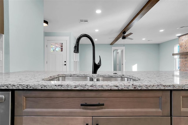 kitchen featuring light stone countertops, sink, ceiling fan, and plenty of natural light