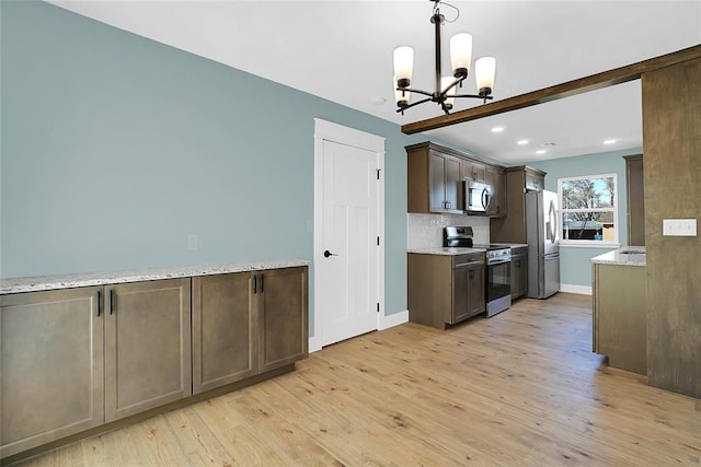 kitchen featuring light stone countertops, stainless steel appliances, light hardwood / wood-style flooring, a chandelier, and hanging light fixtures