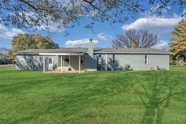 rear view of property featuring a patio area, a yard, and central AC unit