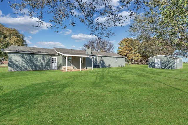 rear view of property with a yard and a storage shed