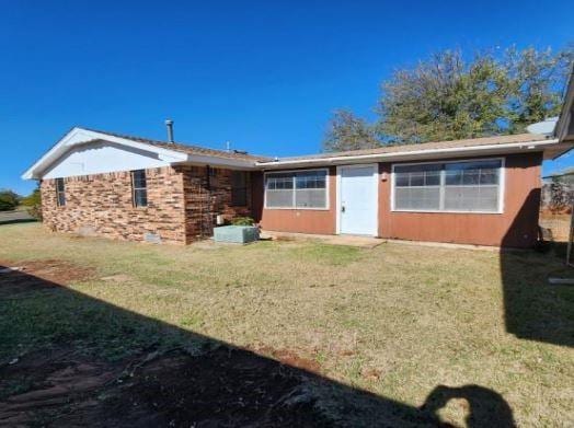 rear view of property with a lawn