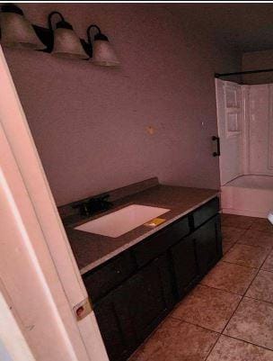 bathroom featuring tile patterned floors, vanity, and a bath