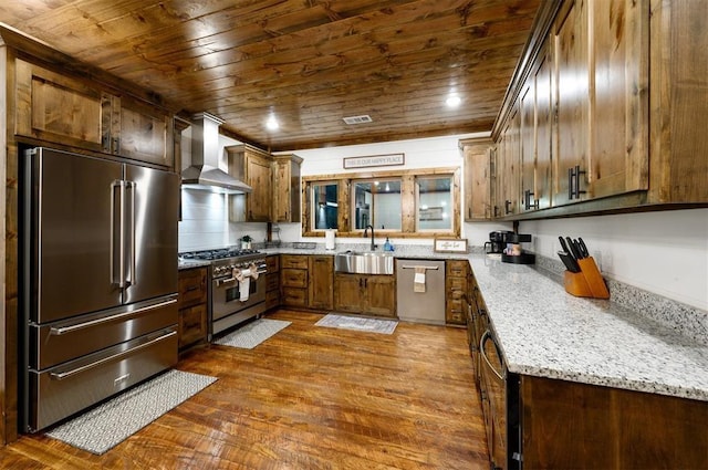 kitchen featuring light stone countertops, dark wood-type flooring, wall chimney range hood, wood ceiling, and high end appliances