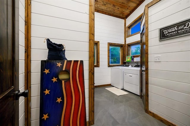 clothes washing area featuring wood walls, wooden ceiling, and independent washer and dryer