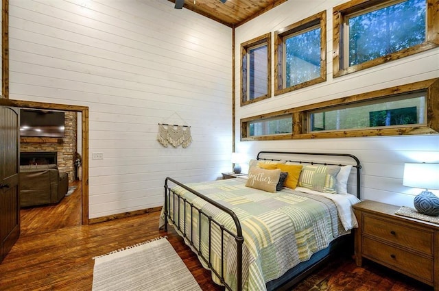 bedroom featuring dark hardwood / wood-style floors, wood walls, and wooden ceiling