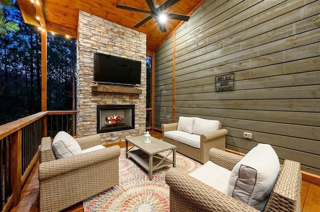 exterior space with an outdoor stone fireplace, wood walls, wood-type flooring, and lofted ceiling