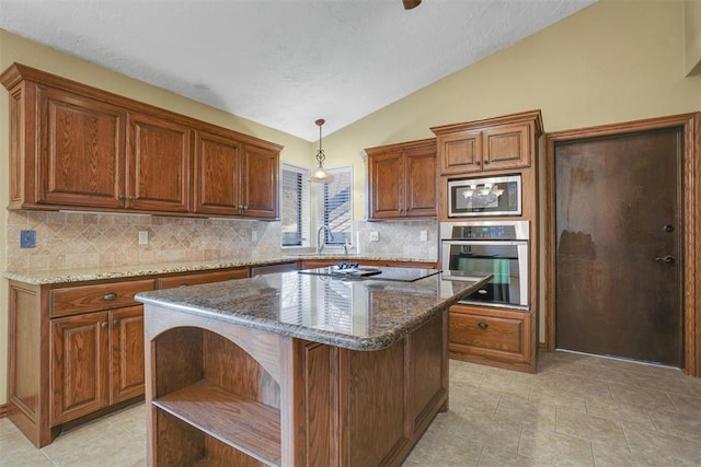 kitchen featuring stainless steel appliances, dark stone countertops, decorative light fixtures, vaulted ceiling, and a kitchen island