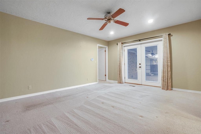 carpeted empty room featuring french doors, a textured ceiling, and ceiling fan